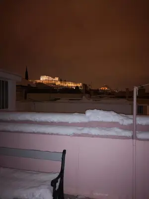a fence with snow on top of it at night at Androniki suite in Athens