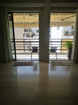 a room with two chairs and a balcony with windows at Androniki suite in Athens