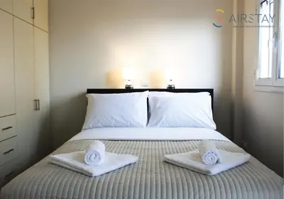 a bedroom with a bed with two towels on it at Anivia Apartments Airport by Airstay in Spáta