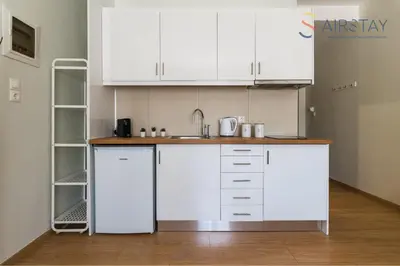 a kitchen with white cabinets and a sink at Anivia Apartments Airport by Airstay in Spáta