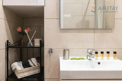 a bathroom with a white sink and a mirror at Anivia Apartments Airport by Airstay in Spáta