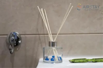 a glass vase with sticks in it on a sink at Anivia Apartments Airport by Airstay in Spáta