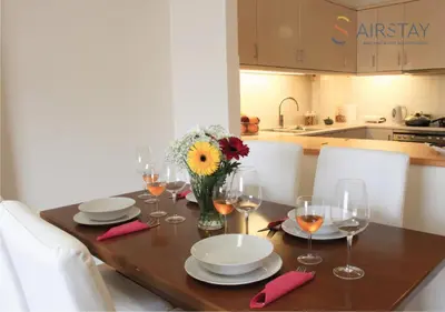 a table with glasses and plates and a vase of flowers at Anivia Apartments Airport by Airstay in Spáta