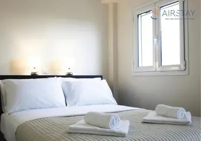 a bedroom with a bed with two towels on it at Anivia Apartments Airport by Airstay in Spáta