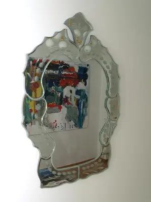 a mirror hanging on a wall with a painting at A Refreshed & Rich in Details Apartment in Piraeus (Passalimani - Marina Zeas) in Piraeus