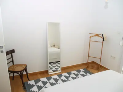 a bedroom with a mirror and a bed and a chair at A Refreshed & Rich in Details Apartment in Piraeus (Passalimani - Marina Zeas) in Piraeus