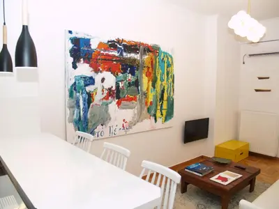 a living room with a painting on the wall at A Refreshed & Rich in Details Apartment in Piraeus (Passalimani - Marina Zeas) in Piraeus