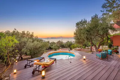 a wooden deck with a swimming pool on a house at Lagonisi Villa Afroditi in Lagonissi