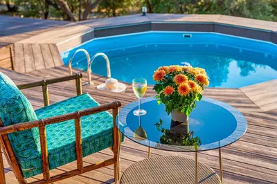 a table with a vase of flowers and a glass of wine at Lagonisi Villa Afroditi in Lagonissi