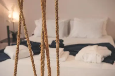 a bed with white sheets and pillows in a room at Piraeus Premium Suites in Piraeus