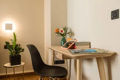 a desk with a chair and a vase of flowers at Klepsydra Urban Suites in Athens