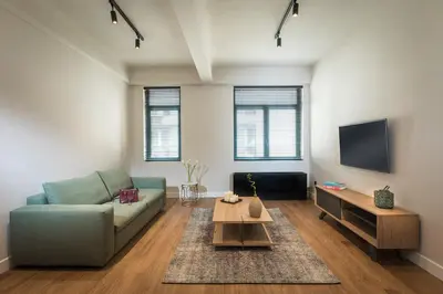 a living room with a couch and a tv at Klepsydra Urban Suites in Athens