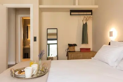 a bedroom with a bed with a tray of food on it at Klepsydra Urban Suites in Athens
