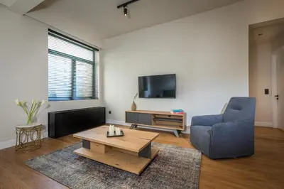 a living room with a blue chair and a coffee table at Klepsydra Urban Suites in Athens