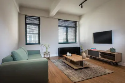 a living room with a couch and a tv at Klepsydra Urban Suites in Athens