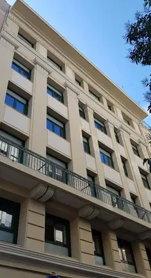 a large building with a balcony on top of it at Klepsydra Urban Suites in Athens