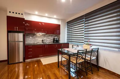 a kitchen with a table and chairs and a refrigerator at Acropolis Koukaki Newly Renovated 55sq.m Apartment in Athens