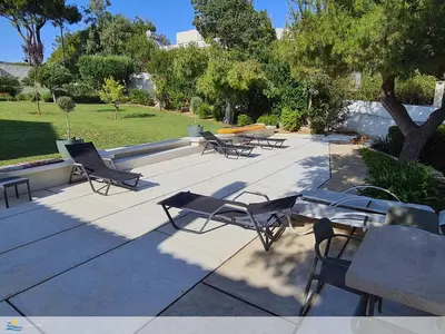 a group of chairs and tables on a patio at Villa PortoMare in Porto Rafti