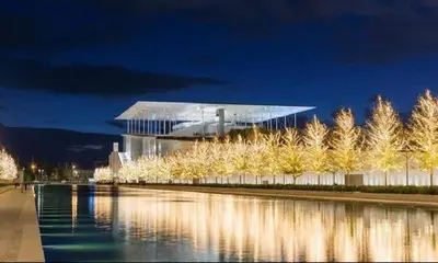 a building with aiety of trees next to a body of water at Family apt with garden next to the sea in Athens