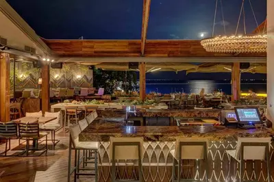 a restaurant with a bar with a view of the ocean at Family apt with garden next to the sea in Athens