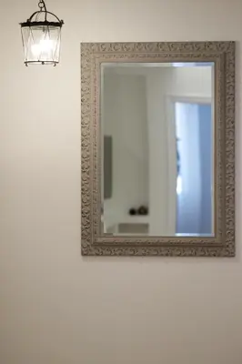 a mirror hanging on a wall with a light at Luxury three bedroom Apartment in Kolonaki in Athens