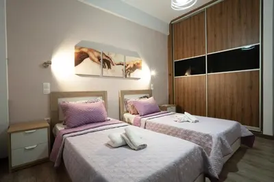 a bedroom with two beds with pink and white sheets at Real Central New Flat - 1' to Metro - Direct Acropolis,Pireus - Best heating and cooling system in Athens