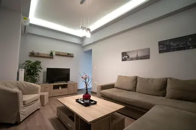 a living room with a couch and a table at Real Central New Flat - 1' to Metro - Direct Acropolis,Pireus - Best heating and cooling system in Athens