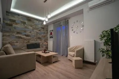 a living room with a couch and a brick wall at Real Central New Flat - 1' to Metro - Direct Acropolis,Pireus - Best heating and cooling system in Athens