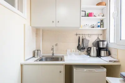a kitchen with white cabinets and a sink at Heart of the City in Athens