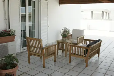 three chairs and a table on a patio at Sunny Studio in Koropíon