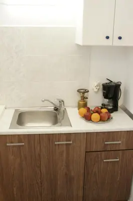 a kitchen counter with a sink and a plate of fruit at Sunny Studio in Koropíon