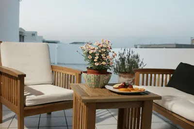 a table with a plate of food on a balcony at Sunny Studio in Koropíon