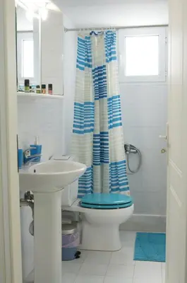 a bathroom with a toilet and a sink at Sunny Studio in Koropíon