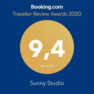 a yellow circle with the number nine and the text travelling review awards at Sunny Studio in Koropíon