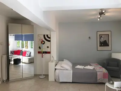 a bedroom with a bed and a living room at Aris sweet home in Athens