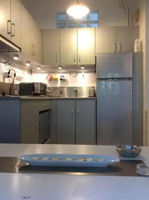a kitchen with a stainless steel refrigerator and a table at Aris sweet home in Athens