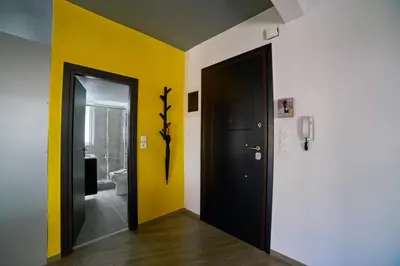 a hallway with a black door and a yellow wall at V&V Central & Elegant Apartment in Athens