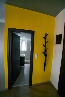 a hallway with a yellow wall and a black door at V&V Central & Elegant Apartment in Athens