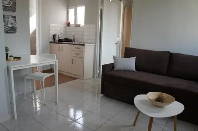 a living room with a couch and a table and a kitchen at A&I Apartments & Studios in Athens
