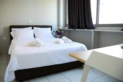 a bedroom with a bed with white sheets and pillows at A&I Apartments & Studios in Athens