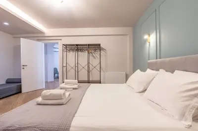 a bedroom with a large white bed with towels on it at Live Life Plaka Apartment in Athens