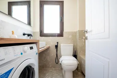 a bathroom with a toilet and a washing machine at Live Life Plaka Apartment in Athens