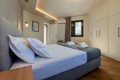 a bedroom with a large bed with white sheets and pillows at Live Life Plaka Apartment in Athens