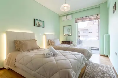 two beds in a room with green walls at Lovely Apartment in Athens in Athens