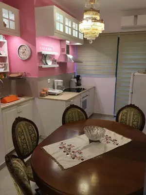 a kitchen with a wooden table and chairs and a kitchen with pink walls at Lovely Apartment in Athens in Athens