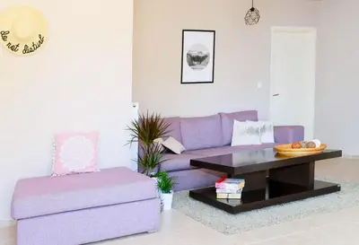 a living room with a purple couch and a coffee table at A&D Apartments in Porto Rafti