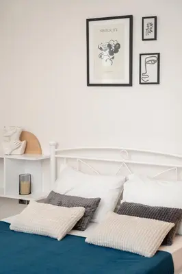 a white bedroom with a bed with pillows on it at A&D Apartments in Porto Rafti