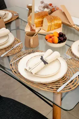 a glass table with plates and fruits and bread at A&D Apartments in Porto Rafti