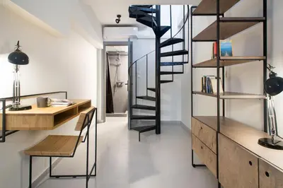 a room with a desk and a spiral staircase at Soho Apartments by Olala Homes in Athens
