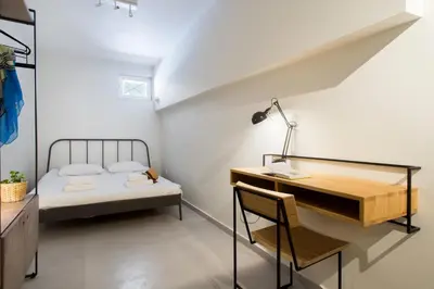 a bedroom with a bed and a desk and a bed and a chair at Soho Apartments by Olala Homes in Athens